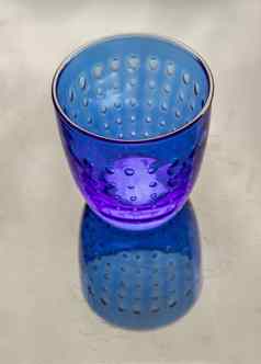 彩色的透明的蓝色的玻璃杯水喝表面反射黑色的背景