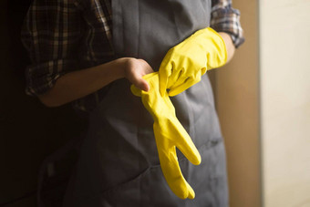 女人黄色的橡胶手套做家务