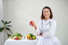 微笑营养学家办公室持有绿色苹果显示健康的蔬菜水果医疗保健饮食概念