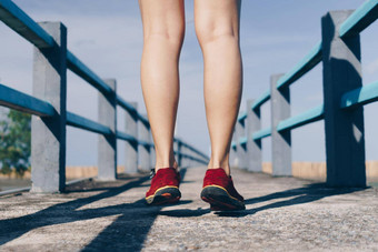 女人穿运行鞋走运行自然绿色背景健康锻炼