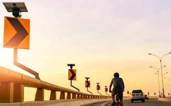 回来视图男人。穿头盔骑自行车<strong>曲线</strong>路汽车安全开车骑路<strong>曲线</strong>路交通标志太阳能面板能源户外锻炼健康的生活方式