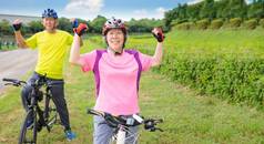 快乐亚洲健康的高级夫妇锻炼自行车