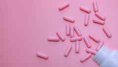 粉红色的胶囊药片传播塑料药物瓶女人的健康保险乳房癌症概念维生素补充健康的皮肤药店网络横幅在线药店背景