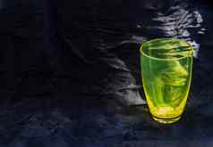 彩色的透明的绿色玻璃杯水喝表面反射黑色的背景