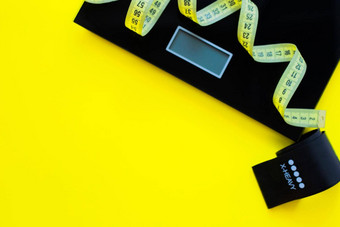 重量规模黑色的健身磁带黄色的测量磁带谎言黄色的背景一边照片前视图平躺复制空间隔离