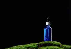 玻璃瓶吸管站绿色莫斯黑色的背景