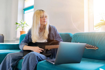 赶时髦的人少年女孩玩电吉他移动PC监控