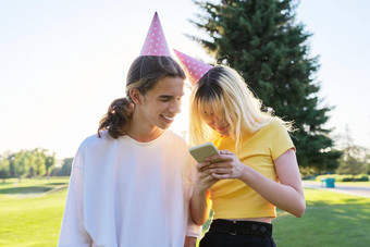 生日聚会，派对夫妇青少年节日帽子智能手机户外