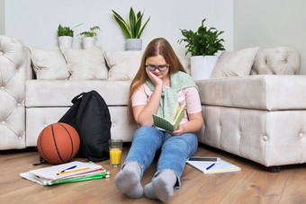 十几岁的女孩坐着首页生活房间地板上阅读书