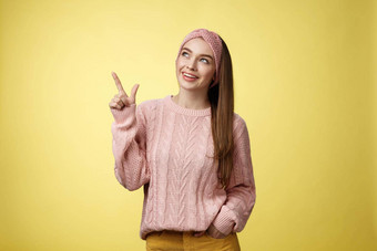肖像逗乐感兴趣可爱的欧洲女孩穿毛衣头巾上左角落里指出横盘整理微笑感兴趣狂喜的捕获好奇的促销黄色的墙