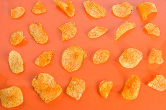 土豆芯片薯片橙色背景电影背景前视图平躺土豆芯片柔和的橙色背景前视图电影概念平躺
