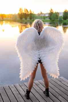 女人白色天使翅膀穿黑色的皮革衣服下降黑暗天使恶魔野兽女孩天使服装万圣节