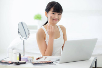 美年轻的亚洲女人学习化妆刷脸颊移动PC电脑教程在线女教学解释使化妆品流<strong>媒体</strong>社会<strong>媒体</strong>