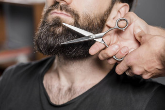 <strong>发型</strong>师手切割男人。胡子剪刀高质量美丽的照片概念