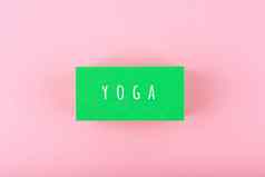 单词瑜伽写绿色矩形明亮的粉红色的背景