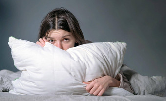 女人覆盖毯子担心失眠压力