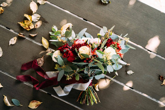 新娘花束白色红色的玫瑰牡丹分支机构桉树树alstroemeria菊花红色的浆果白色栗色丝带表格