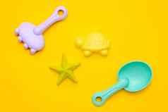 塑料海滩玩具柔和的颜色黄色的背景发展细电动机概念创造力游戏夏天概念