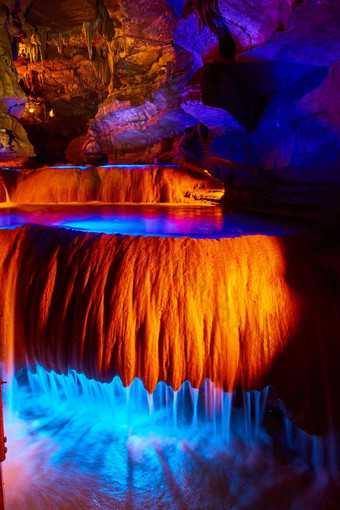 瀑布地下洞穴流动岩石形成橙色蓝色的灯