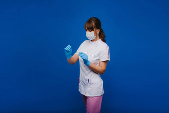 有吸引力的年轻的女医生持有手术刀直接相机概念医疗保健治疗手术肖像医疗医生蓝色的背景