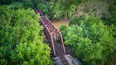空中视图大金属桥火车跟踪河包围绿色树