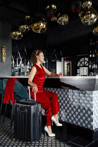 年轻的业务女人酒吧酒店手提箱旅行概念