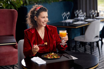 优雅的年轻的女人吃虾沙拉午餐奢侈品餐厅健康的生活方式饮食概念
