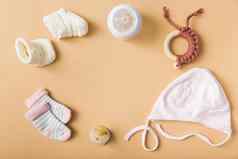 婴儿袜子一对羊毛鞋子奶嘴帽牛奶瓶玩具橙色背景高质量美丽的照片概念