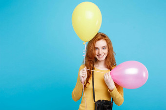 生活方式聚会，派对概念关闭肖像年轻的美丽的有吸引力的姜红色的头发女孩色彩斑斓的气球古董相机蓝色的柔和的背景复制空间