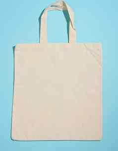 空亚麻生态友好的米色帆布手提包袋品牌蓝色的背景清晰的可重用的袋食品杂货模拟