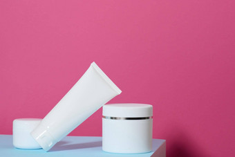 Jar空白色塑料管化妆品粉红色的背景包装奶油过来这里血清广告产品促销活动