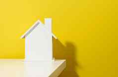 白色木房子黄色的背景真正的房地产租赁购买出售概念房地产经纪人服务