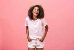 照亮生活微笑无忧无虑的有魅力的快乐非洲美国女非洲式发型发型时尚的装笑大声快乐娱乐持有手口袋粉红色的墙