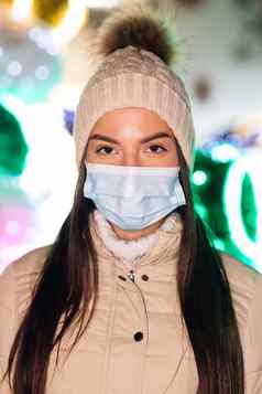 垂直拍摄关闭肖像高加索人年轻的女医疗脸面具站装饰圣诞节城市人群人生病的疫情冠状病毒流感大流行流感电晕病毒