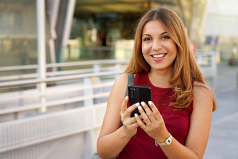 巴西女孩智能手机地铁站快乐的年轻的女人聊天移动电话相机在户外