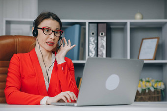 女人穿耳机沟通会议调用说话电脑首页办公室顾问会说话的客户虚拟闲谈，聊天电脑应用程序概念沟通生活方式