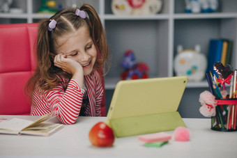 好奇的可爱的学前教育孩子女孩数字平板电脑技术<strong>设备</strong>小孩子持有垫电脑冲浪互联网玩游戏首页孩子们科技上瘾概念