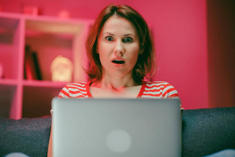 惊讶女人脸移动PC屏幕关闭兴奋女人看在线新闻电脑肖像快乐女孩购物网站移动PC