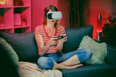 女人测试虚拟现实眼镜坐着沙发首页室内高加索人女耳机脸玩游戏微笑沙发上现代公寓