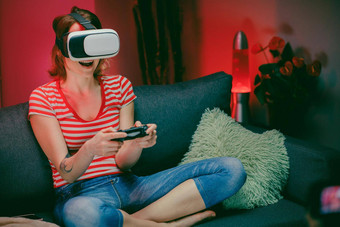 女人坐着沙发护目镜玩视频游戏放松女人享受视频游戏