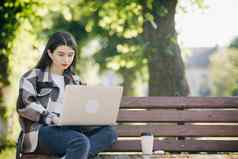 年轻的学生看教训在线研究公园女人大学大学学生移动PC电脑研究工作技术在线教育概念