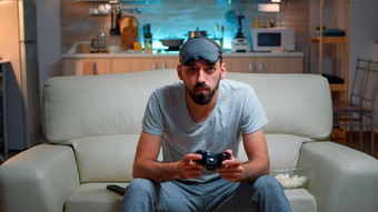 前面视图为玩家坐着沙发前面电视玩电子游戏竞争