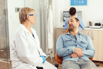 高级医生口腔学家讨论病人检查口服健康