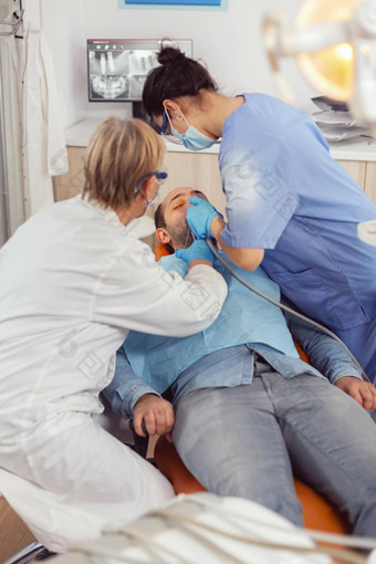 高级女人牙医检查镜子生病的病人健康