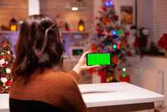 年轻的女人持有智能手机绿色屏幕