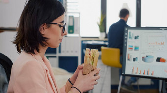 企业家女人吃美味的三明治外卖lunchbreak工作金融图