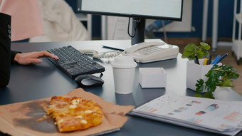 特写镜头女商人坐着桌子上前面电脑吃披萨片