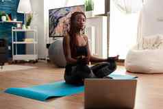 黑色的女人坐着瑜伽席练习平静