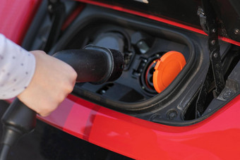 女人插头充电器套接字现代红色的电车女人堵塞电车辆充电车电池停车