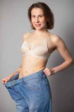 女人失去重量饮食苗条的女人身体大牛仔裤健康的饮食结果年轻的女人享受重量损失首页快乐女牛仔裤成功的饮食在室内